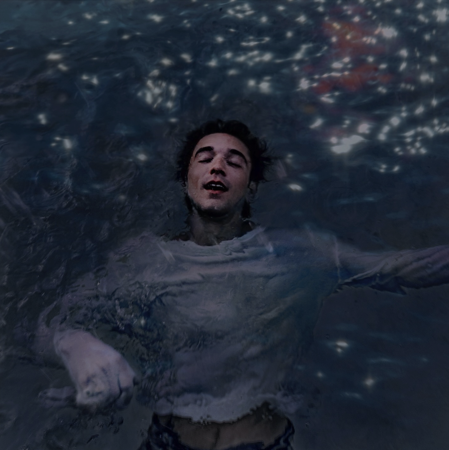 Daniel floating in a dark blue pool of water.